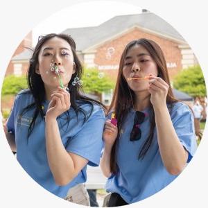 Two students blow bubbles at ACPHS Springfest